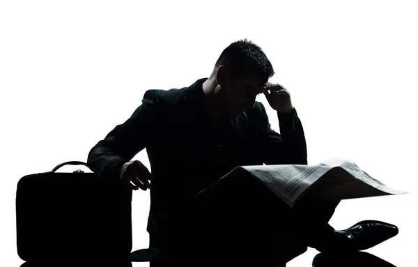 Silhouette man despair full length sitting reading newspaper — Stock Photo, Image