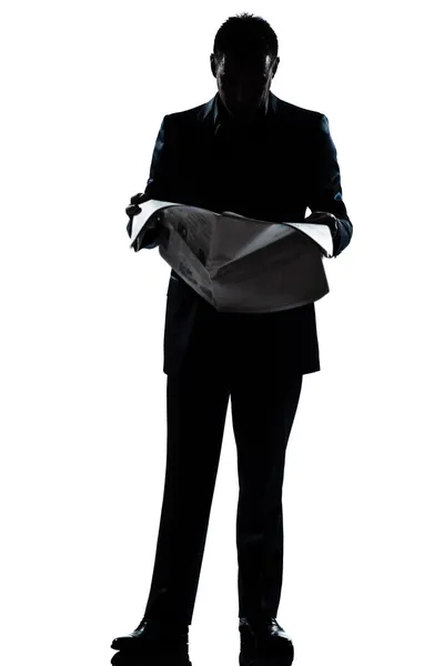 Silhouette man full length standing reading newspaper — Stock Photo, Image
