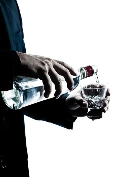 Las manos del hombre silueta se cierran vertiendo alcohol blanco — Foto de Stock