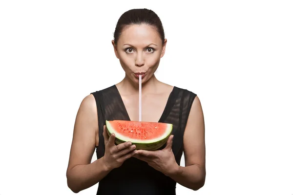 Retrato de una hermosa mujer bebiendo jugo a través de sandía — Foto de Stock