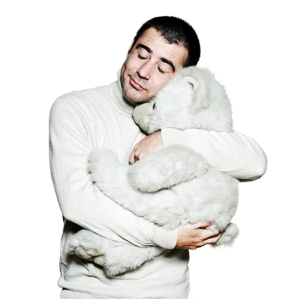 Мужчина обнимает плюшевого мишку с закрытыми глазами — стоковое фото