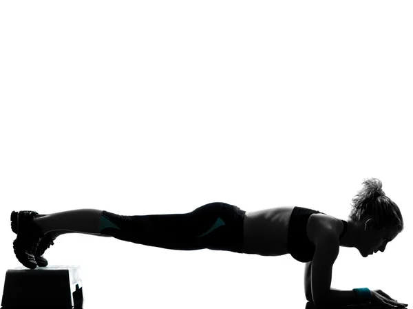 Woman exercising step aerobics push ups Royalty Free Stock Photos