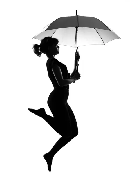 Silhueta mulher voando segurando guarda-chuva aberto — Fotografia de Stock