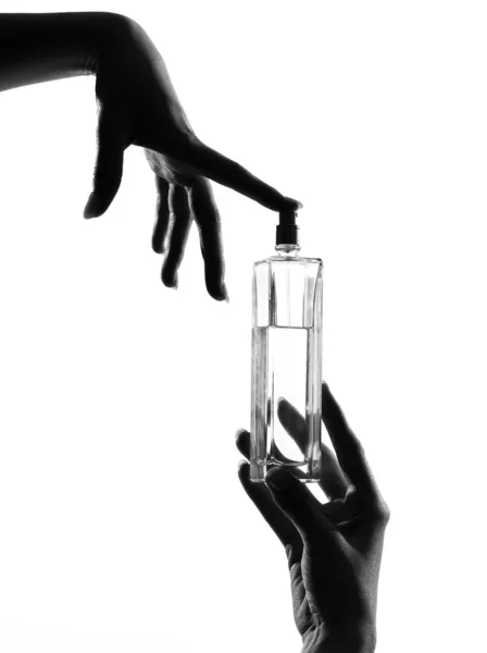 Detail close-up silhouette woman hands with perfume — Stock Photo, Image