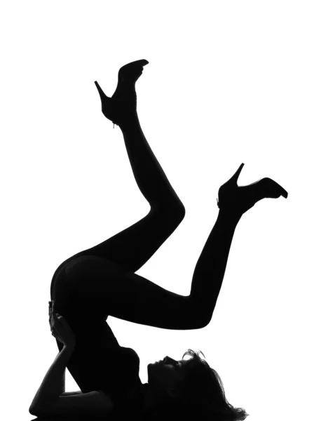 Mulher silhueta deitada no chão pernas ginásticas — Fotografia de Stock