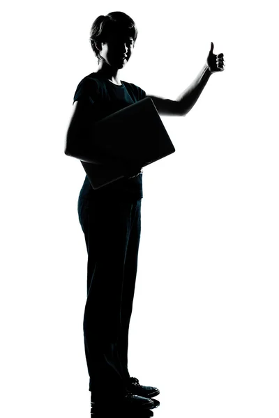 Una silueta adolescente sosteniendo portando el pulgar del ordenador portátil —  Fotos de Stock