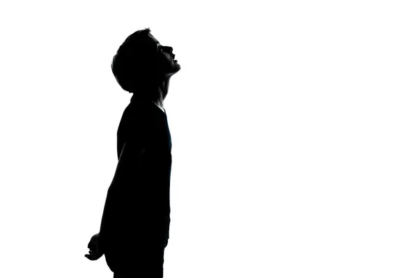 Um jovem adolescente menino ou menina olhando para cima silhueta — Fotografia de Stock