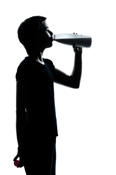 Bir genç genç erkek ya da kız içme sütü siluet — Stok fotoğraf