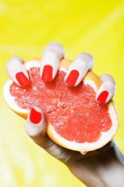 Woman Hand Squeezing a grapefruit clipart