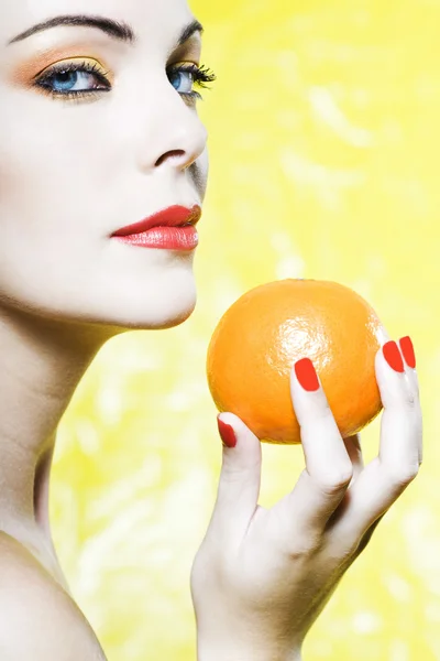 Retrato de mulher mostrando uma fruta tangerina laranja — Fotografia de Stock