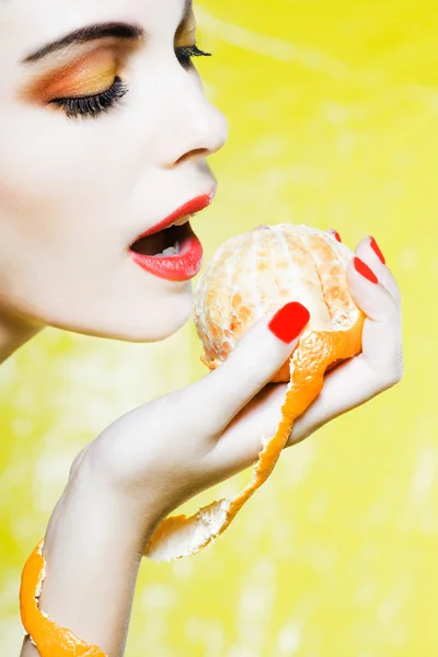 Женский портрет, поедающий мандаринский апельсиновый мандарин — стоковое фото