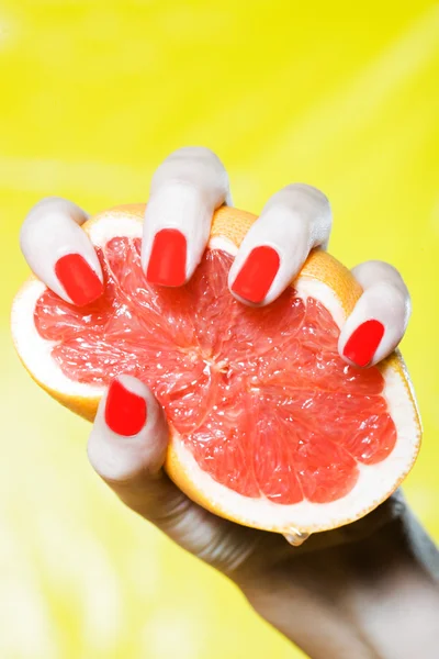 Frau drückt Hand auf eine Grapefruit — Stockfoto