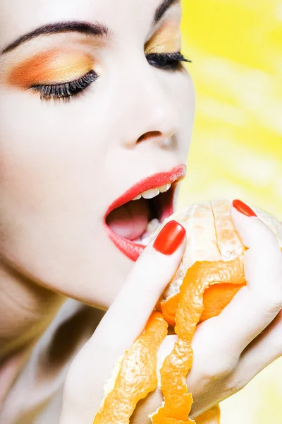Женский портрет Ешьте апельсиновый мандарин — стоковое фото