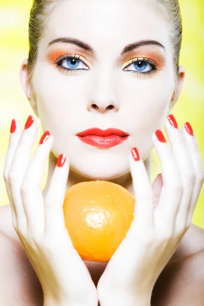 Frauenporträt mit einer orangefarbenen Mandarine — Stockfoto