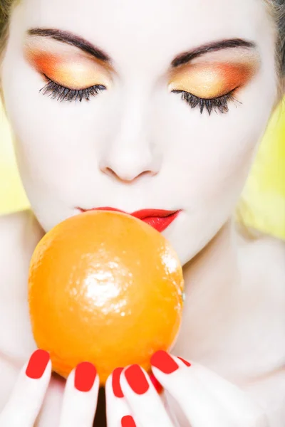 Frauenporträt, das eine Mandarine riecht — Stockfoto