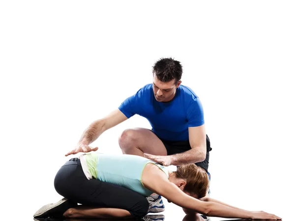 Инструктор по йоге позиционирует женщину в позе адхо мукха вирасаны. — стоковое фото