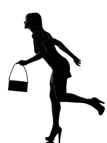 Silhueta elegante mulher correndo segurando bolsa — Fotografia de Stock