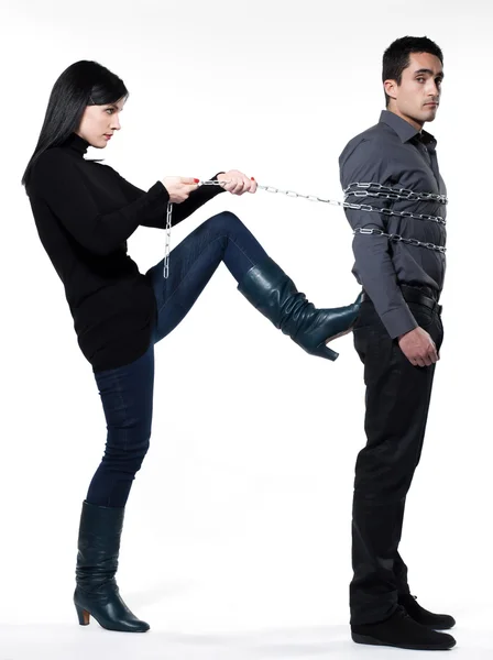 Mujer restringiendo a un hombre encadenado — Foto de Stock