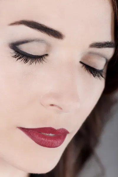 Vacker kvinna ögonen slutna och röda läppar på nära håll — Stockfoto