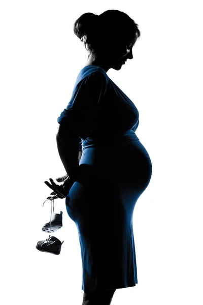 Портрет беременной женщины с детской обувью — стоковое фото