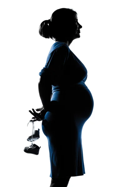 Těhotná žena portrét drží dětské boty — Stock fotografie