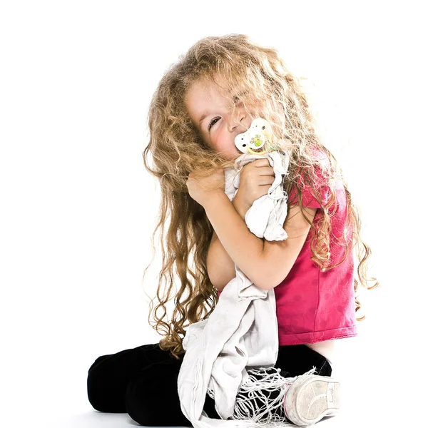 Маленькая девочка обнимает соску и одеяло улыбается весело — стоковое фото