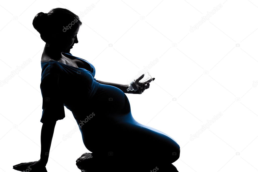 Pregnant woman sitting holding babby bottle