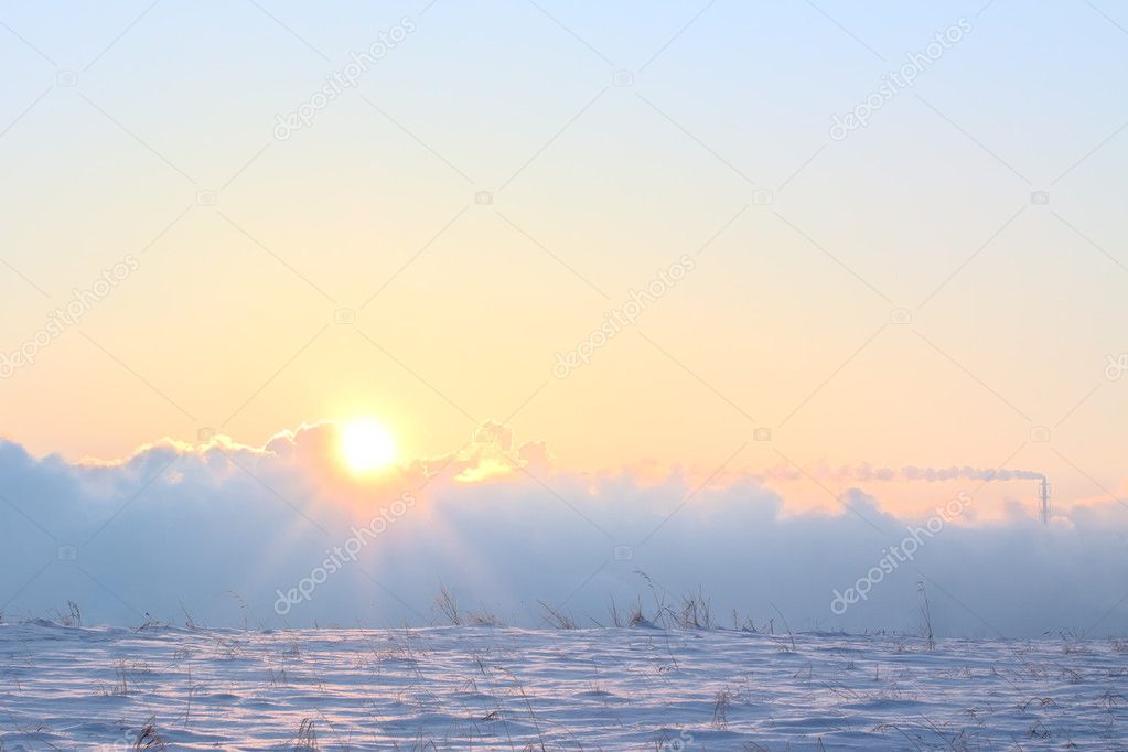 Winter sun in smoke of factory