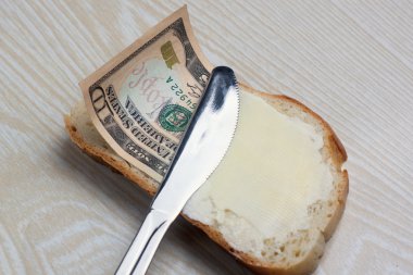 Butter and money on a slice of bread clipart