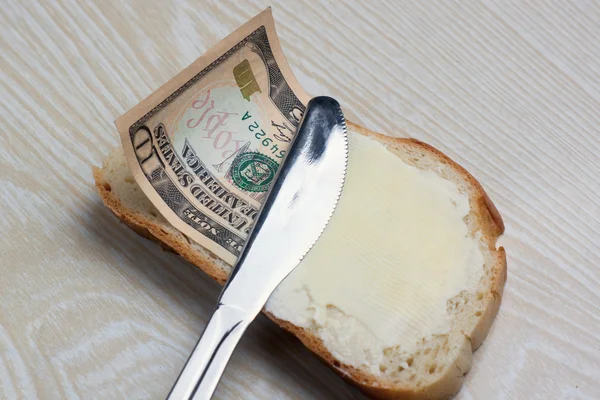 Manteiga e dinheiro em uma fatia de pão — Fotografia de Stock