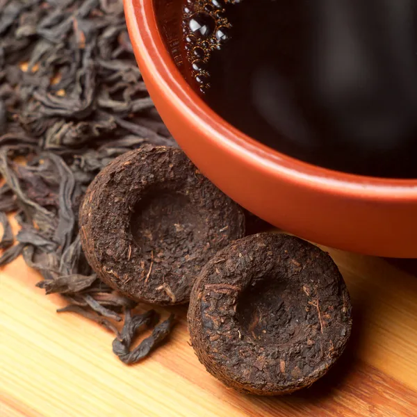 The cup of pu-erh and two bricks of pu-erh tea — Stock Photo, Image