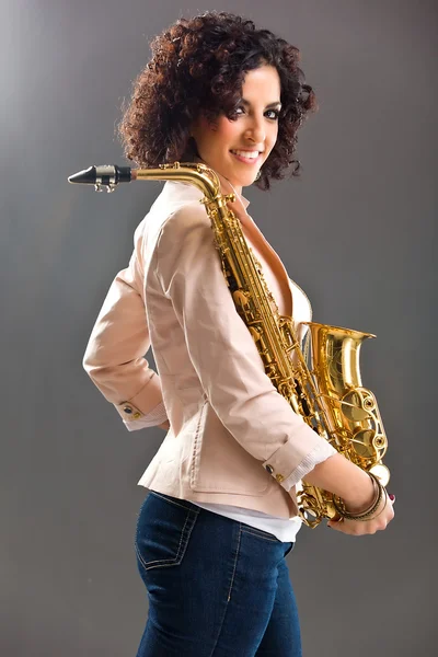 Piękna dziewczyna z saksofon na szarym tle — Zdjęcie stockowe