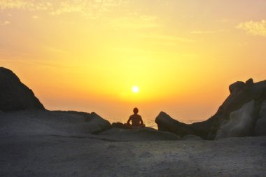 Yoga yapan bir kadın silueti.