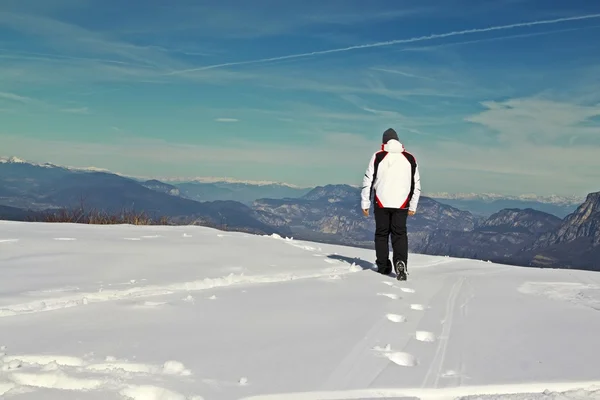 Homem andando sobre a neve — Fotografia de Stock