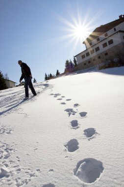 Silhouette of a man walking in the snow clipart