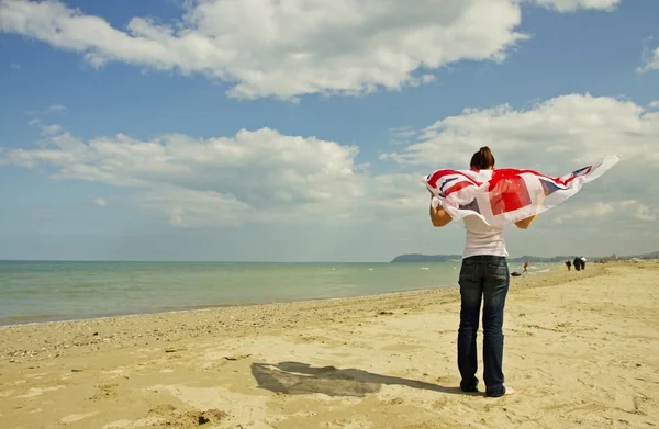 Девушка на пляже с британским флагом — стоковое фото