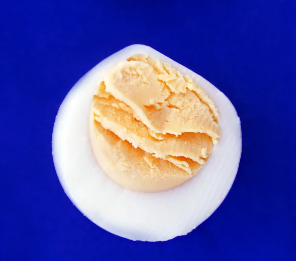 Hartgekochtes Ei vor blauem Hintergrund. Makro — Stockfoto
