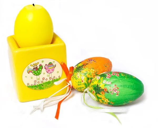 Жовта пасхальна свічка та декоративні яйця ізольовані на білому — стокове фото