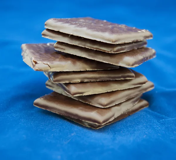 Chocolate pieces on blue — Stock Photo, Image
