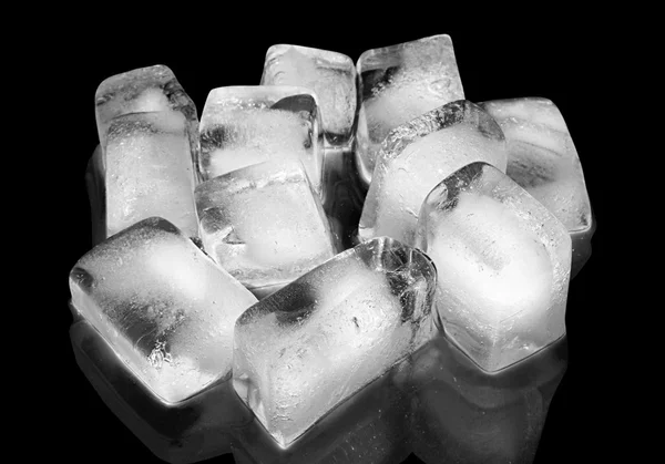 Cubi di ghiaccio nel bicchiere con riflesso su fondo nero . — Foto Stock