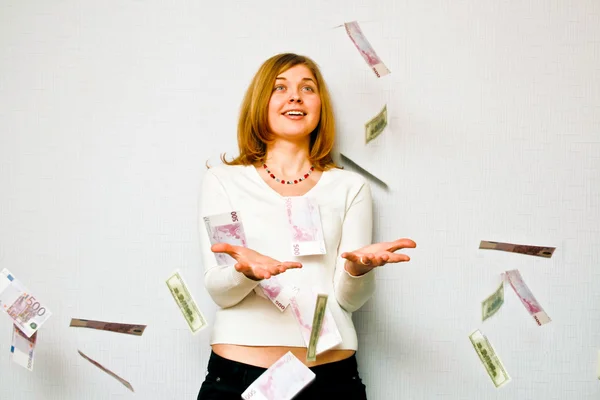 Mulher com dinheiro caindo no fundo branco — Fotografia de Stock