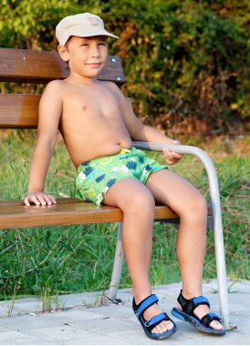 Boy smiling and sitting on bench