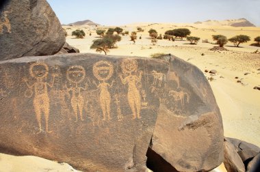 Ancient rock art in Sahara depicting four figures clipart