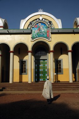 Ethiopian priest in front of church clipart