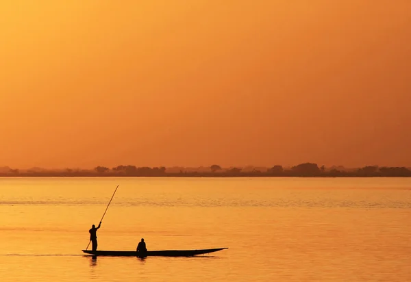 Silhueta de pescador africano em canoa — Fotografia de Stock