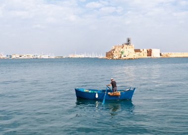 Fisherman in the boat at inner harbor of Brindisi town,Italy clipart