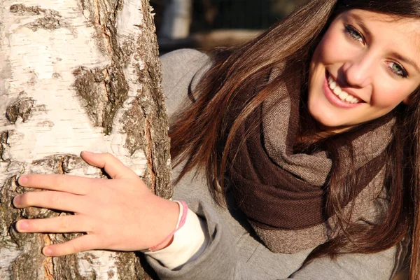 Smiling girl behind a birch — Stock Photo, Image