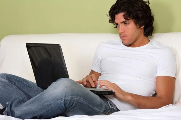 Jonge man werken vanuit huis met laptop — Stockfoto