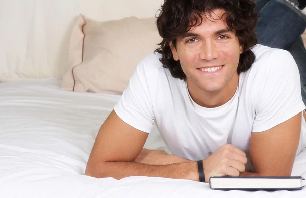Smiling guy on bed — Stock Photo, Image
