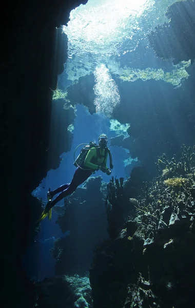 Scuba Diver in a cave with sunbeams — Stock Photo, Image
